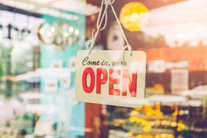 Open sign hanging in store window welcoming customers